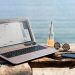 Foto: Jobbe under ferien med datamaskin på stranden.