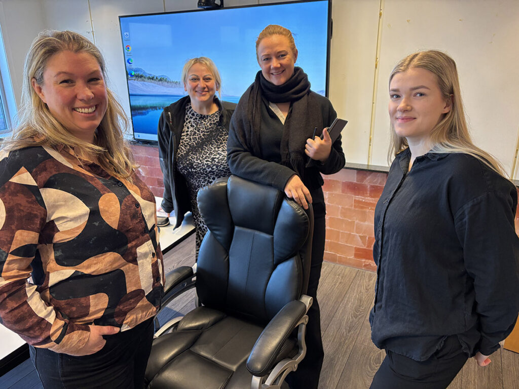 4 damer samlet rundt en kontorstol etter en revisjon.