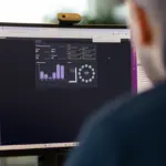Mann ser på dataskjerm med forskjellige grafiske feamstillinger av data fra et HMS-system