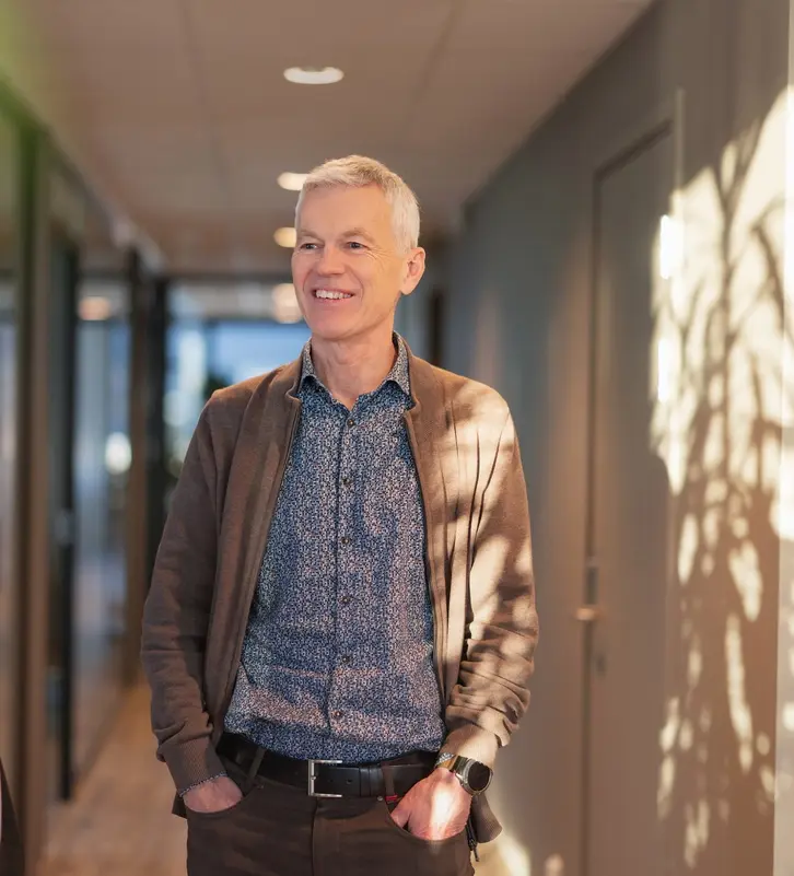 To menn snakker sammen i et kontorlandskap.